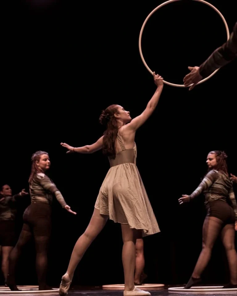 gala de danse, lumière, danseuse au centre avec un cerceau, autres danseuses autour